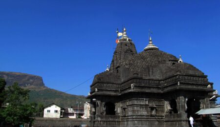 Trimbakeshwar Mandir spire against a clear blue sky.